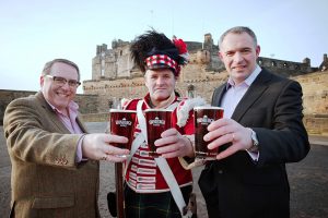 Three chaps raise a pint of the new Edinburgh Castle beer on the esplanade