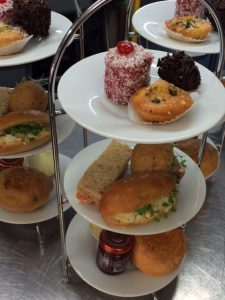 3 tier cake stand with cakes, scones and sandwiches
