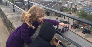 Two children at Edinburgh Castle pointing down at the city of Edinburgh