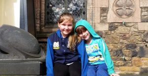 Two girls sitting in front of Edinburgh Castle