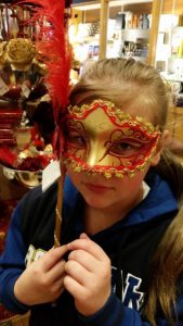 Girl trying on a mask in the gift shop