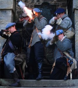 Costumed performers firing muskets
