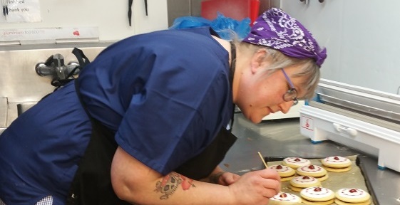 A baker decorating biscuits
