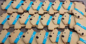 Photograph of shortbread biscuits shaped like dogs, with blue icing colours