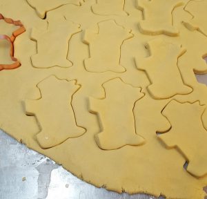 a cookie cutter being used to cut out scottie dogs from dough