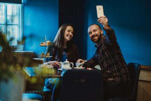Couple having afternoon tea in The Tea Rooms and taking a selfie