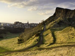 A view over the city of Edinburgh, showing Salisbury Crags and Edinburgh Castle beyond