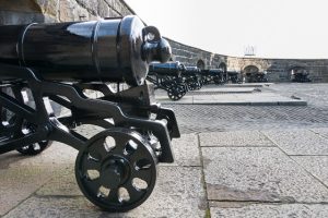 row of canons in front of a wall