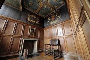 A wood paneled room with a painted ceiling