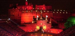Edinburgh Castle lit in red and seating stands on esplanade