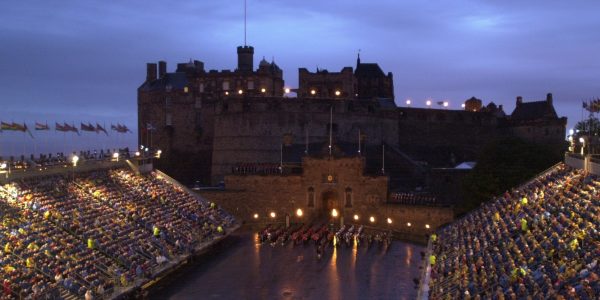 View of the Castle Esplanade by night with a military band marking in formation lit up by coloured lights