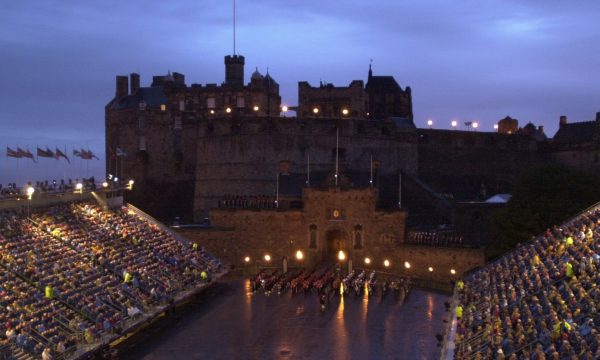 View of the Castle Esplanade by night with a military band marking in formation lit up by coloured lights
