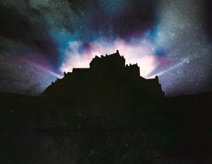 Silhouette of Edinburgh Castle with dramatic lighting emitting from within