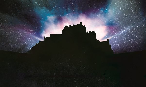 Silhouette of Edinburgh Castle with dramatic lighting emitting from within