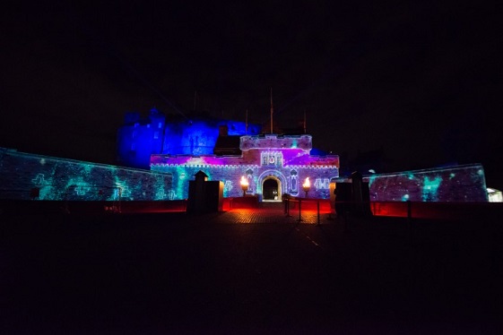 The main entrance to Edinburgh Castle illuminated by colourful projections