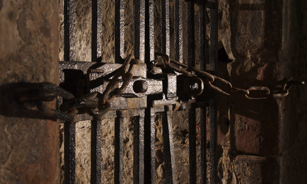 A heavy door, featuring heavy iron bars and locks.