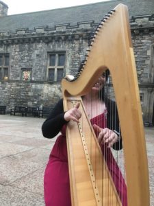 Toni playing the clarsach in a courtyard at Edinburgh Castle
