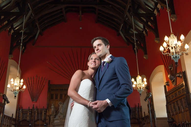 A couple pose for a wedding shoot under the timber roof of the Great hall in Edinburgh Castle