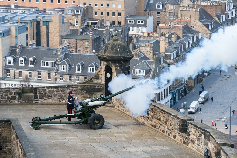 A soldier firing a gun from the battlements of Edinburgh Castle