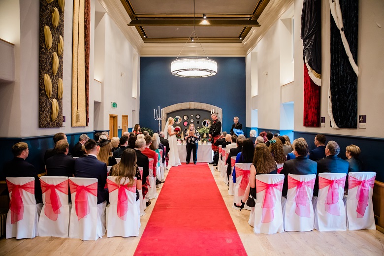 Guests awaiting the arrival of the bride in a room lavishly decorated for a wedding at Edinburgh Castle