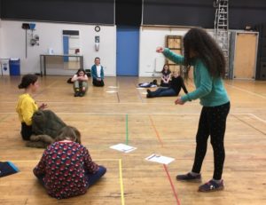 Children rehearse for a play inside a school hall
