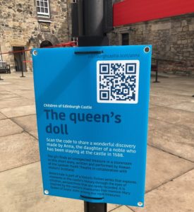 A sign within Edinburgh Castle featuring a QR code for visitors to scan