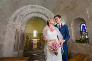 A promotional photo of a bride and groom in a small chapel at Edinburgh Castle