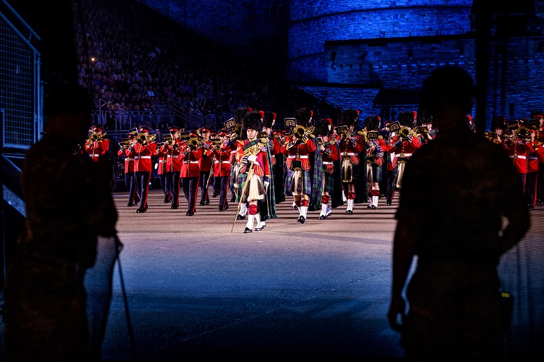 A marching band wearing kilts performs at the military tattoo at Edinburgh Castle