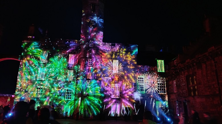 Colourful projections illuminate the facade of a building at Edinburgh Castle